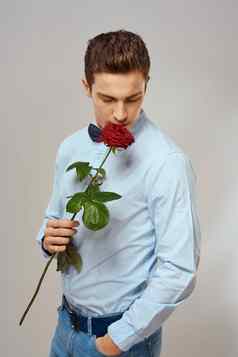 浪漫的男人。红色的玫瑰光衬衫裤子西装