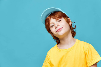 肖像红发男孩头倾斜的一边蓝色的帽复制空间
