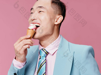 快乐的男人。亚洲外观吃冰奶油享受生活方式优雅的风格粉红色的背景