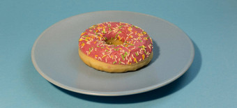 粉红色的甜甜圈甜甜圈彩色的洒蓝色的背景咬美国百吉饼