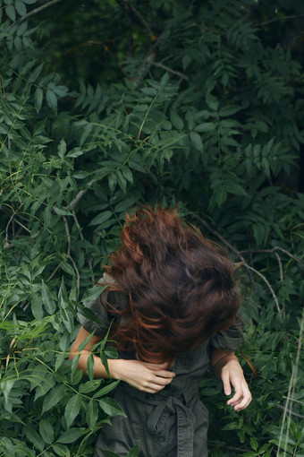 肖像女人靠向前绿色叶子灌木自然旅行