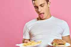 男人。白色t恤汉堡生活方式粉红色的背景吃