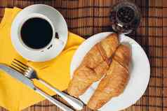 新鲜的羊角面包表格咖啡杯早餐