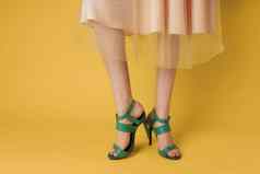 时尚鞋子绿色鞋子女脚购物黄色的背景
