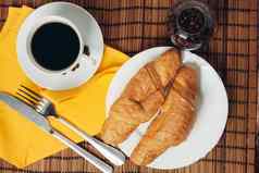 新鲜的羊角面包表格咖啡杯早餐餐