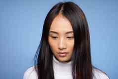 女人亚洲外观肖像蓝色的背景白色毛衣模型