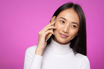 女人亚洲外观会说话的电话生活方式技术粉红色的背景工作室