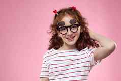 快乐的女孩时尚眼镜发型装饰条纹t恤粉红色的背景