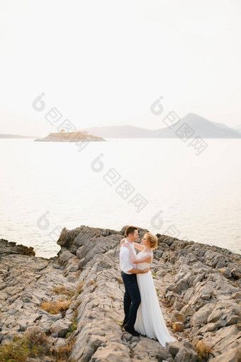 新娘新郎拥抱岩石海背景山岛脸红