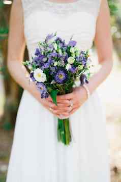 温柔的新娘持有婚礼花束蓝色的白色水马齿利西安图斯薰衣草手特写镜头