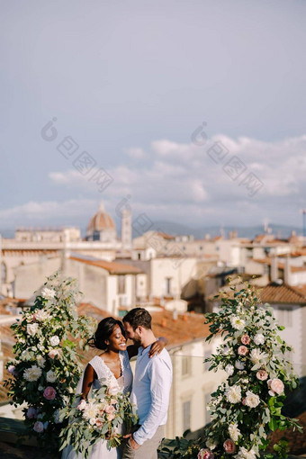 跨种族婚礼夫妇目的地艺术婚礼弗洛伦斯意大利婚礼仪式屋顶建筑城市景观的观点城市大教堂圣诞老人玛丽的花