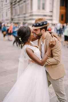 多民族的婚礼夫妇非裔美国人新娘高加索人新郎接吻人群广场的大教堂婚礼弗洛伦斯意大利