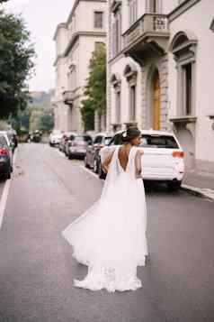 婚礼弗洛伦斯意大利非裔美国人新娘回来相机白色衣服长面纱走路城市街
