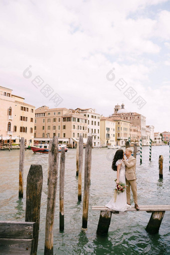 意大利婚礼威尼斯新娘新郎站木码头船贡多拉条纹绿色白色系泊波兰人背景外墙大运河建筑