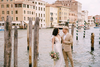 意大利婚礼威尼斯新娘新郎站木码头船贡多拉条纹绿色白色系泊波兰人背景外墙大运河建筑