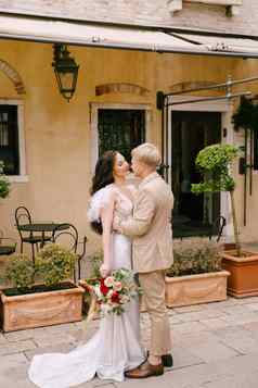 意大利婚礼威尼斯新娘新郎走废弃的街道城市新婚夫妇吻背景房子