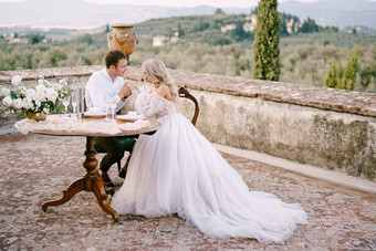婚礼酒庄别墅托斯卡纳意大利婚礼夫妇坐着晚餐表格屋顶别墅新郎持有新娘手
