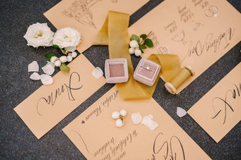 婚礼环盒子邀请卡片丝绸丝带白色玫瑰黑色的背景开销前视图