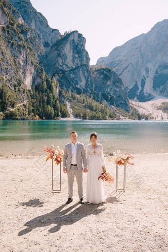 新娘新郎站的地方仪式拱秋天花列背景泻湖布雷斯意大利目的地婚礼欧洲布雷斯湖