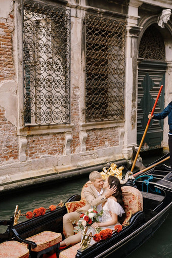 意大利婚礼威尼斯用凤尾船运送卷新娘新郎经典木贡多拉狭窄的威尼斯运河新婚夫妇坐着船鼻子鼻子游泳背景<strong>伪造</strong>的晶格