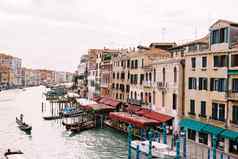 威尼斯意大利10月大运河路堤威尼斯里亚尔托桥桥人骑美丽的木电动机船船夫携带游客大船只人站码头