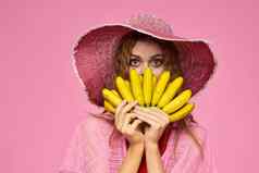 女人香蕉手他异国情调的水果生活方式粉红色的背景