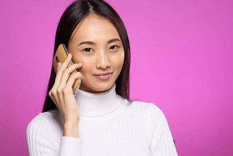 女人亚洲外观会说话的电话技术生活方式粉红色的背景