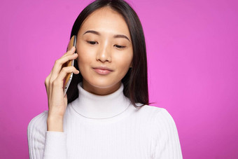女人亚洲外观会说话的电话技术生活方式粉红色的背景