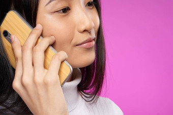 漂亮的亚洲女人会说话的电话技术特写镜头