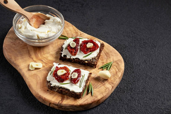 自制的杂粮面包三明治奶油奶酪晒干的西红柿木盘健康的吃概念复制空间