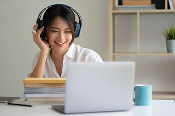 亚洲女人穿耳机研究在线看网络研讨会播客移动PC听学习教育会议调用网络学习概念