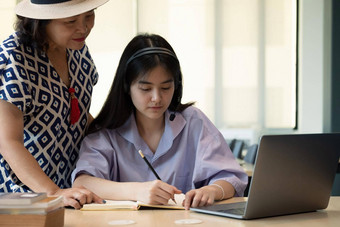 亚洲妈妈。电脑笔记本教学女儿学习研究在线首页在家教育在线概念