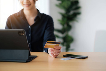 女人休闲衬衫支付信贷卡在线使订单应用程序平板电脑成功的快乐业务女人使事务移动银行应用程序