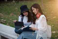 学生坐着公园阅读书沟通研究教育大学大学研究生概念