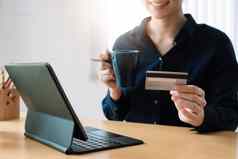 女人的手持有信贷卡数字平板电脑在线购物首页