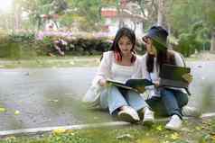 年轻的漂亮的女大学学生户外研究辅导准备未来考试公园大学