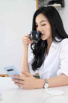 肖像亚洲女业务金融检查港口股票市场移动应用程序早....咖啡