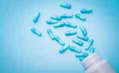 蓝色的抗生素胶囊药片传播塑料药物瓶蓝色的背景抗生素药物电阻抗菌药物过度使用处方药物制药行业健康预算