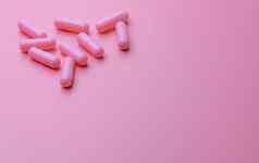 粉红色的胶囊药片粉红色的背景女人健康保险预算药店商店横幅制药行业维生素补充胶囊药片行业快乐药片药片爱