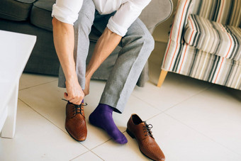男人。灰色的休闲裤紫色的衣服袜子棕色（的）鞋子