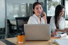 肖像有吸引力的亚洲女商人工作移动PC调用移动电话业务策略规划