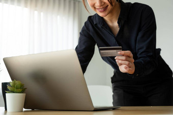 年轻的女人持有信贷卡移动PC电脑首页在线购物电子商务互联<strong>网银</strong>行支出钱