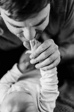 爸爸吻婴儿的小手特写镜头黑色的白色照片