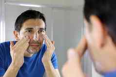 男人。洗脸面部清洁剂脸洗肥皂镜子浴室首页但皮肤护理概念