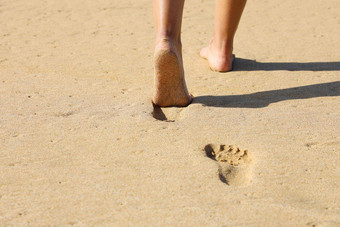海滩女人<strong>腿脚</strong>走光着脚沙子离开的足迹金沙子日落假期旅行自由人放松夏天