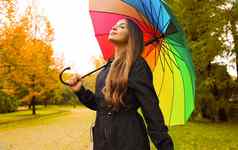肖像快乐女人穿雨衣伞呼吸城市公园多雨的一天