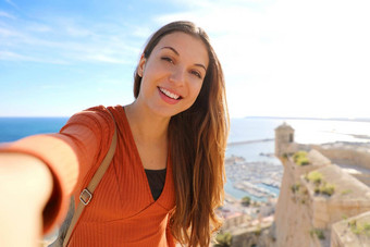 微笑美丽的旅游女人采取自拍照片利坎特西班牙旅行者女孩采取肖像圣诞老人芭芭拉城堡利坎特西班牙语旅游目的地欧洲