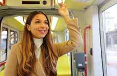 年轻的业务女人持有处理移动现代有轨电车快乐乘客享受旅行公共城市运输