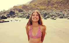 微笑好玩的年轻的女人海滩相机快乐拉丁女孩红色的白色条纹比基尼肖像年轻的晒黑女人放松海滩