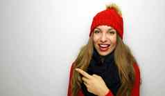 肖像愉快的女人穿着红色的毛衣蓝色的围巾指出手指孤立的白色背景复制空间